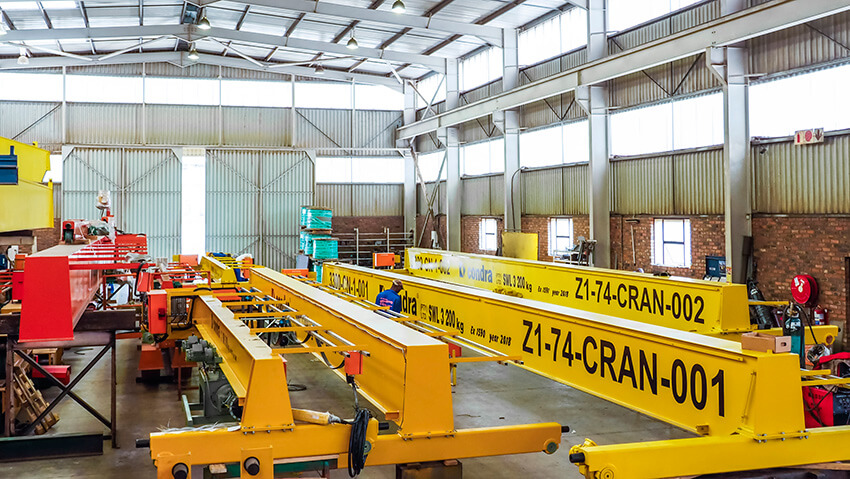 Three overhead cranes (finished in yellow) for Kamoto Copper Company, nearing completion in Condra’s Johannesburg factory.
